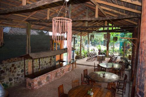 un restaurante con mesas y sillas y una lámpara de araña en Rafters Retreat, en Kitulgala