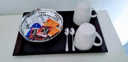 a table with a black tray with a plate and utensils at One World Mirissa in Mirissa