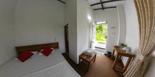 Cette petite chambre comprend 2 lits et une fenêtre. dans l'établissement Kandy Mountain Cottage, à Kandy