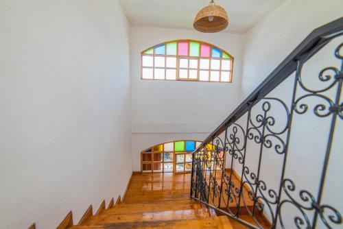 a hallway with a staircase with stained glass windows at El Andariego in Otavalo