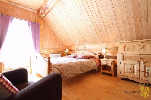 a bedroom with a bed in a wooden room at Chalets de Fougerousse in Chambon-sur-Lac