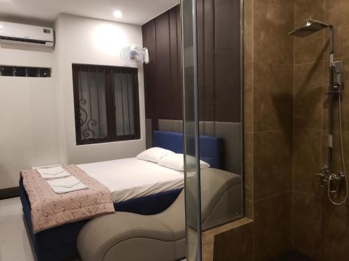 a small bedroom with a bed and a shower at Biên Hòa Hotel in Bien Hoa
