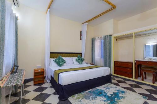 a bedroom with a bed and a sink and a desk at Jacyjoka Apartments Nyali in Mombasa