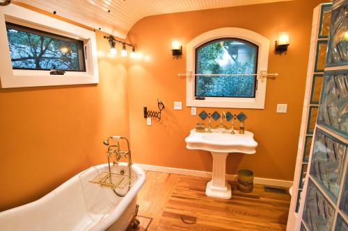 an orange bathroom with a tub and a sink at Regal Victorian Home in Downtown Calistoga in Calistoga