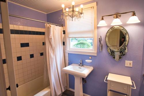 a blue bathroom with a sink and a mirror at Regal Victorian Home in Downtown Calistoga in Calistoga