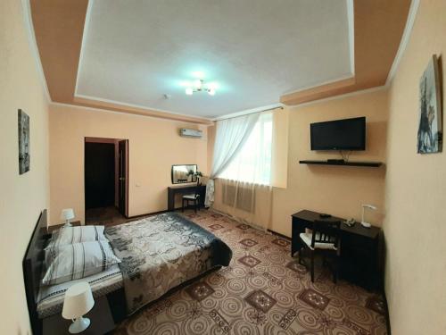 a hotel room with a bed and a television at Hotel Dio Lakrua in Shakhty