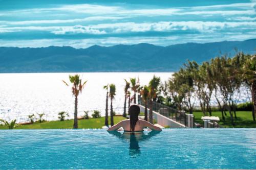 a woman sitting in a swimming pool looking at the water at ON'LIVE HOTEL in Çeşme