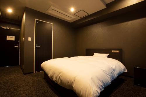 a bedroom with a large bed with white sheets at HOTEL PAR-MAN in Chiba