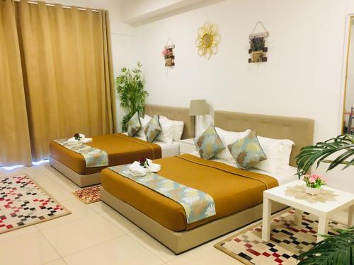 a room with two beds and a living room at Studio I-Soho D'Gunduls Homestay by DGH I-CITY in Shah Alam