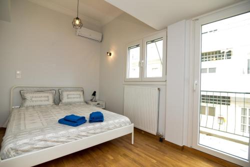une chambre avec un lit avec deux serviettes bleues dessus dans l'établissement Athens Sea view 2 floor apartment next to Marina, à Athènes