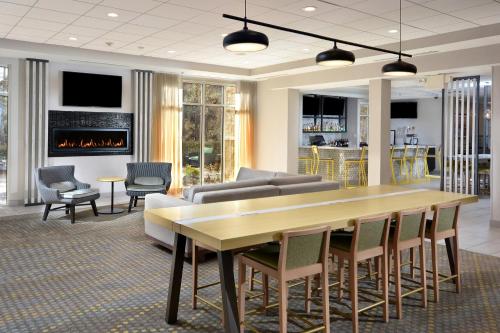 a living room with a table and chairs and a fireplace at Holiday Inn Raleigh Durham Airport by IHG in Morrisville