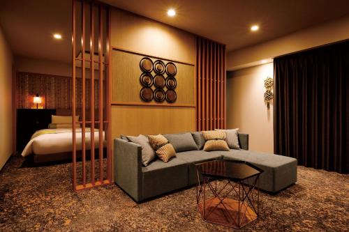 a living room with a couch and a bed at Daiwa Roynet Hotel Nara Natural Hot Spring in Nara