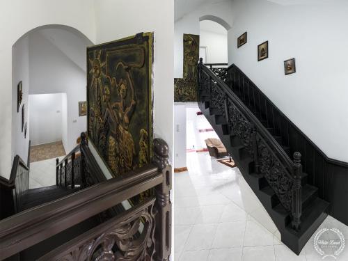 a hallway with stairs with a painting on the wall at White Land City Hotel in Dambulla