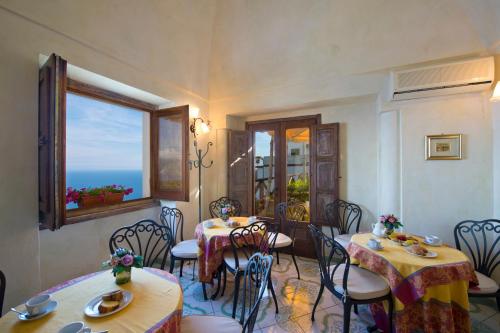 um restaurante com mesas e cadeiras com vista para o oceano em L'Antico Borgo Dei Limoni em Amalfi