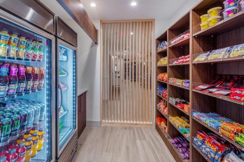 a grocery store aisle with shelves of drinks at Holiday Inn Express & Suites - Rice Lake by IHG in Rice Lake