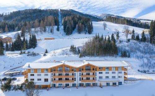 a large building in the snow with a mountain at Skylodge Alpine Homes in Haus im Ennstal