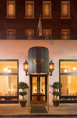a building with a door with a clock on it at Planters Inn on Reynolds Square in Savannah