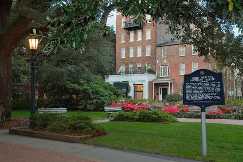 a sign in a park in front of a building at Planters Inn on Reynolds Square in Savannah