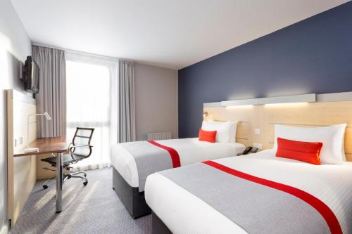 a hotel room with two beds and a desk at Holiday Inn Express Southwark by IHG in London