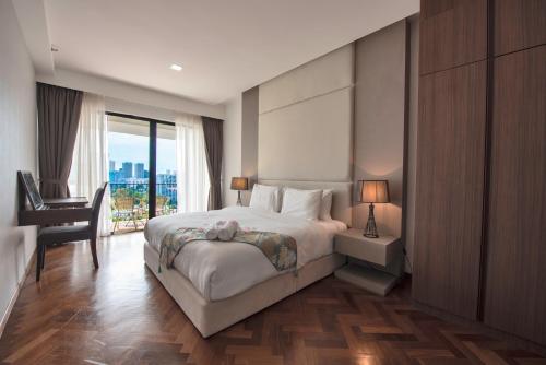 a bedroom with a bed and a desk and a window at The Landmark by Katana in George Town