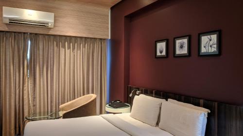 En eller flere senge i et værelse på Hotel Sankam Residency