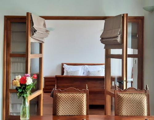 a bedroom with two bunk beds and a table with a vase of flowers at Résidence Le Hublot in Antananarivo