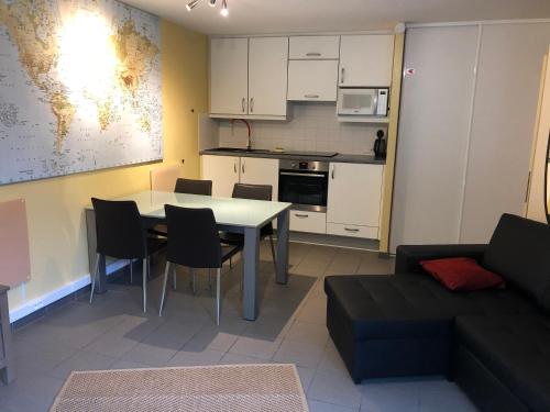 a kitchen and living room with a table and a couch at Prinses Elisabeth in Koksijde