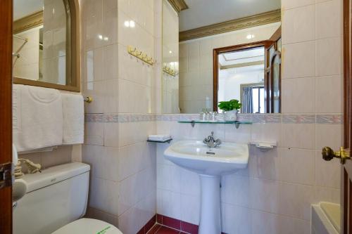 a bathroom with a sink and a toilet and a mirror at The Spring Hotel in Ho Chi Minh City
