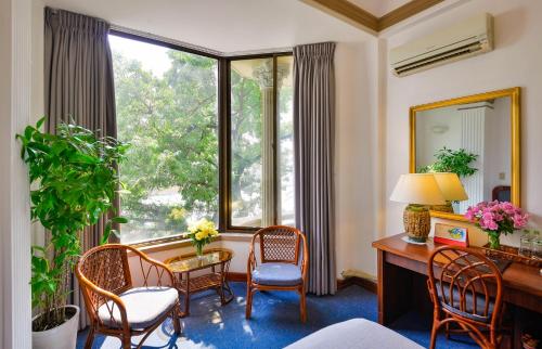 a room with a desk and chairs and a large window at The Spring Hotel in Ho Chi Minh City