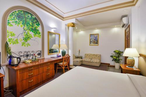 a bedroom with a bed and a desk at The Spring Hotel in Ho Chi Minh City
