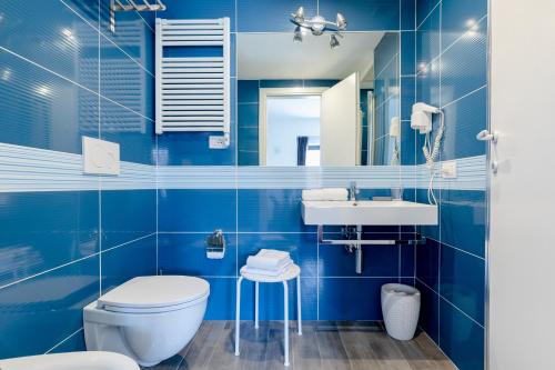 ローマにあるRhome Accomodationの青いタイル張りのバスルーム(トイレ、シンク付)