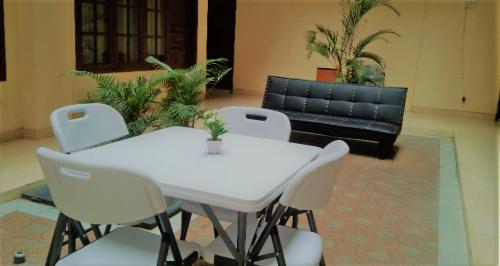 una mesa blanca y sillas en una habitación con sofá en Residence Duksina 2 By SHM, en Yogyakarta