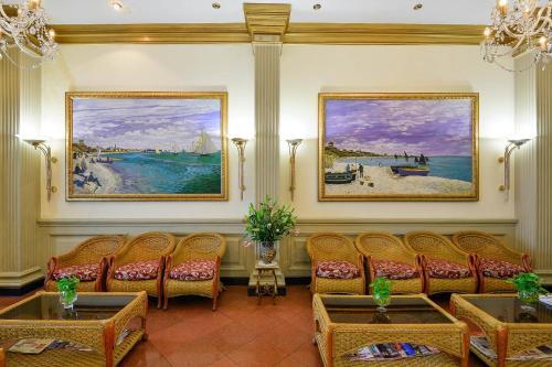 a waiting room with chairs and paintings on the wall at The Spring Hotel in Ho Chi Minh City