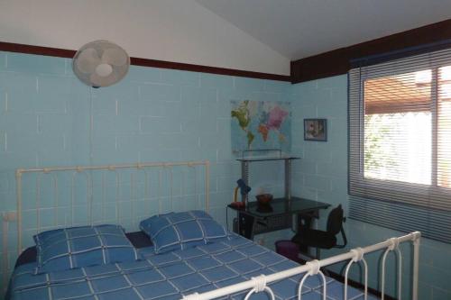 サント・クロチルドにあるMaison Joss Villaの青いベッドルーム(ベッド1台、デスク付)