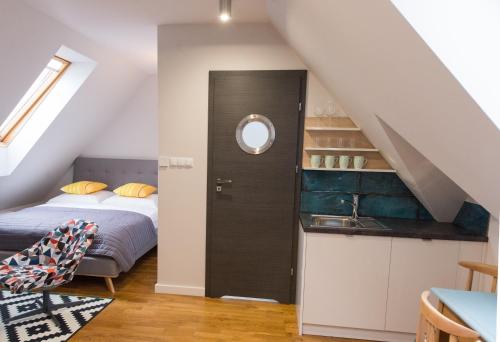 a small attic bedroom with a bed and a sink at Studio Jaworzyna in Krynica Zdrój