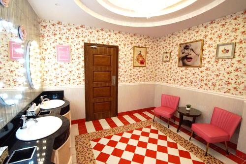 a bathroom with two pink chairs and a sink at Central Park Reef Resort in Olongapo