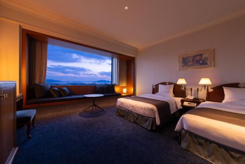 Habitación de hotel con 2 camas y ventana grande. en Rihga Royal Hotel Hiroshima, en Hiroshima