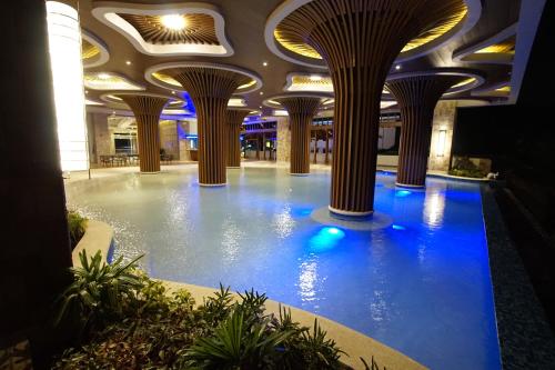 una gran piscina cubierta en un edificio con columnas en Central Park Reef Resort en Olongapo
