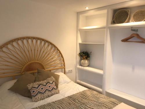 Schlafzimmer mit einem Bett mit einem Kopfteil aus Holz und Regalen in der Unterkunft Can Estrellas apartamento vista mar in Begur