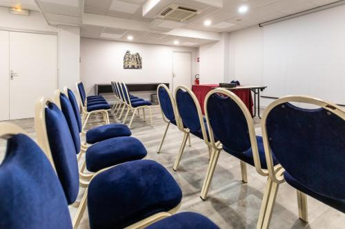 a waiting room with blue chairs and a table at Hôtel The Originals City Le Berry - proche centre-ville - Gare in Bourges