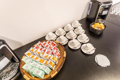 a counter top with a basket of towels and cups at Hôtel The Originals City Le Berry - proche centre-ville - Gare in Bourges