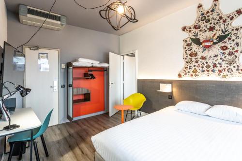 a hotel room with a bed and a desk and a chair at Hôtel The Originals City Le Berry - proche centre-ville - Gare in Bourges