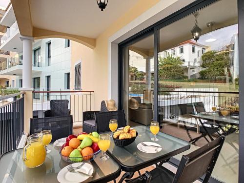 a dining room with a table with fruit on a balcony at Apartment Lotus by LovelyStay in Funchal