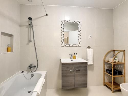 a bathroom with a tub and a sink and a mirror at Apartment Lotus by LovelyStay in Funchal