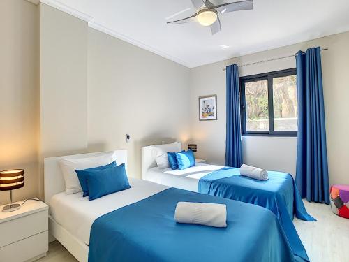 two beds in a room with blue and white at Apartment Lotus by LovelyStay in Funchal