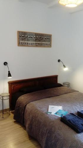 een slaapkamer met een bed met twee lampjes aan de muur bij B&B Bouton D'Or La Bouriotte in Labastide-Rouairoux