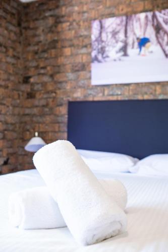 a hotel room with two beds with white sheets at Leski Club in Jindabyne