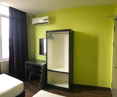 a bedroom with a mirror and a desk and a bed at SARIKEI GARDEN HOTEL in Sarikei