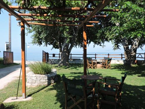 a pergola with a table and chairs under a tree at Pandora Studios in Kala Nera