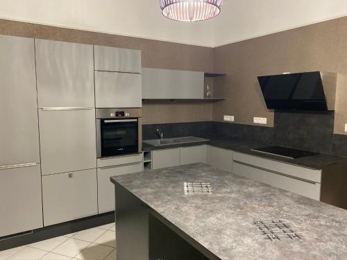 une cuisine avec des armoires blanches et un comptoir dans l'établissement A La Villa Perroy les chambres sont spacieuses et les petit-déjeuners offerts, à Dunkerque